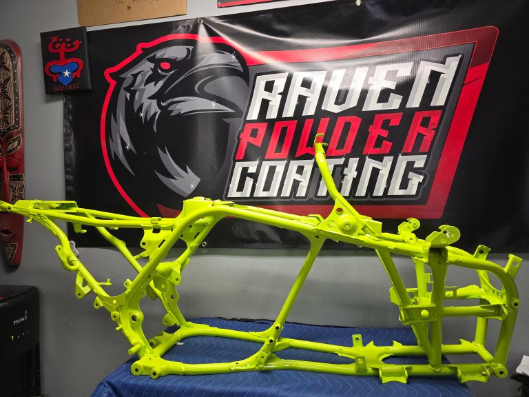 Motorcycle frame displayed in front of the Raven banner