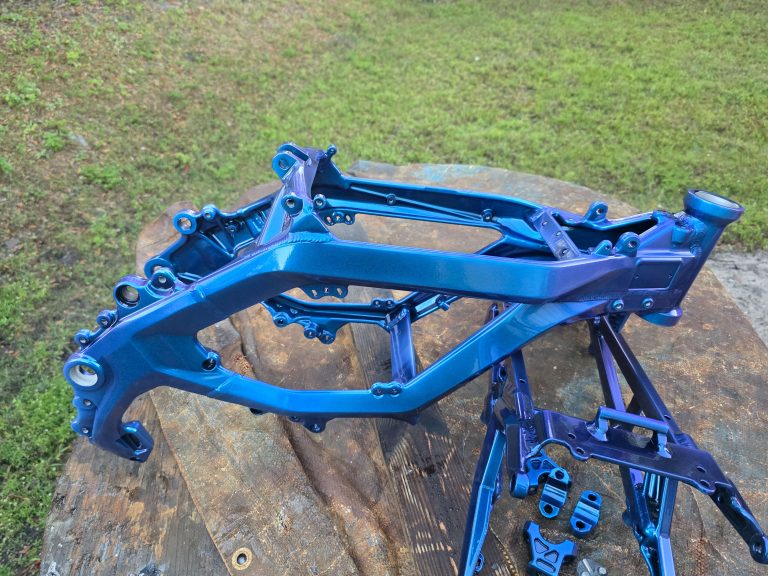 Motorcycle frame and smaller parts on an outdoor stand