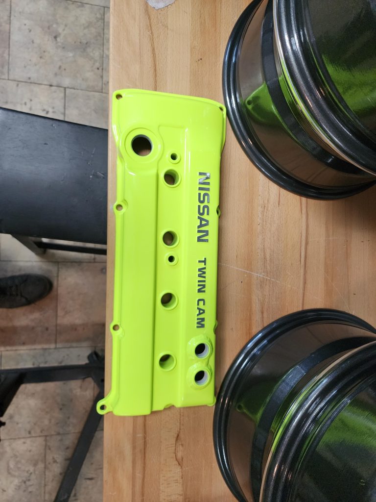 Engine cover on a workbench beside wheels