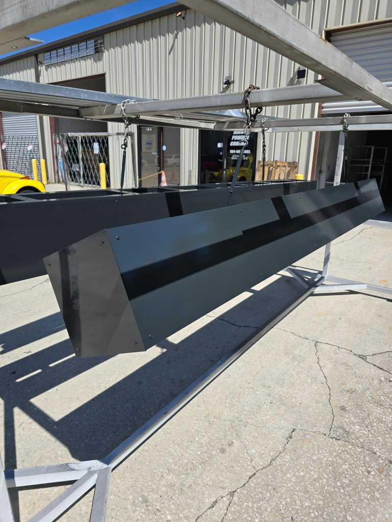 Long fabricated sign panel suspended outdoors