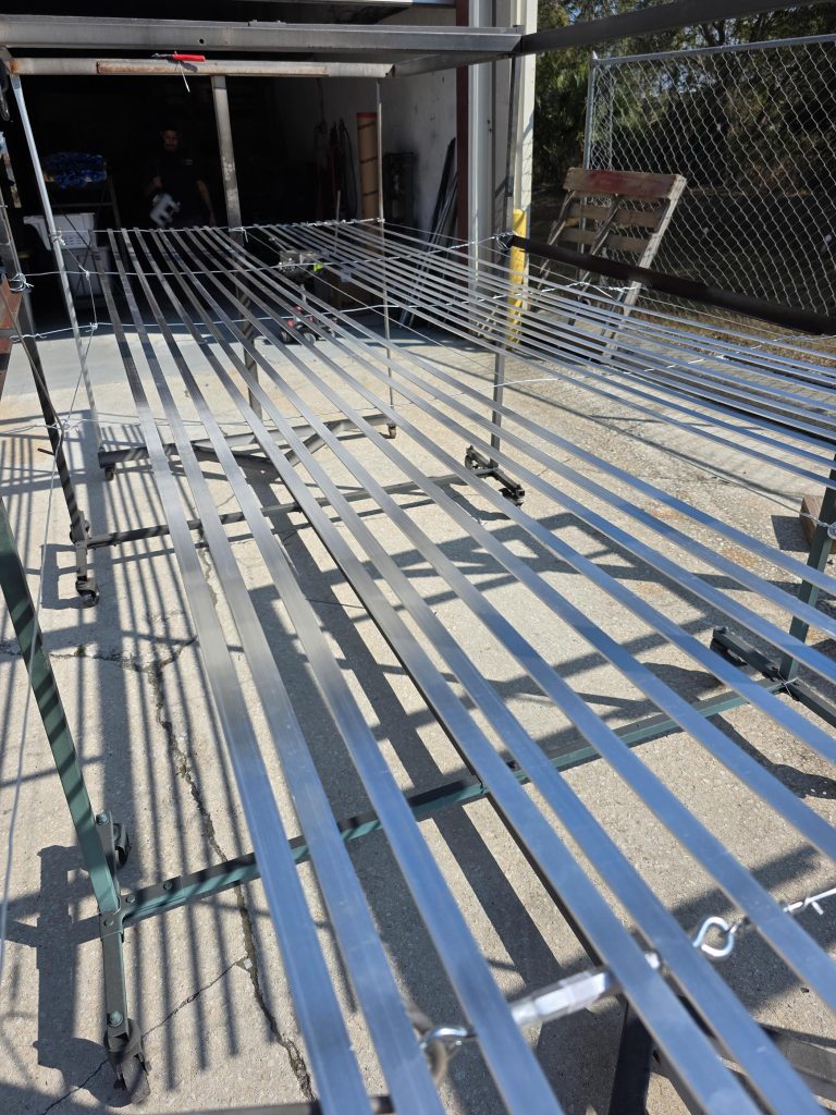 Rows of long narrow pieces arranged on a rack outdoors
