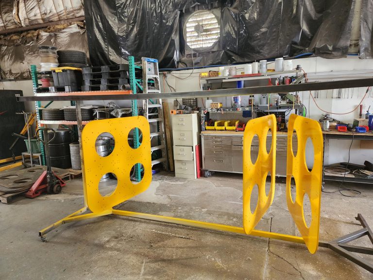 Panels with circular openings suspended from a workshop rack