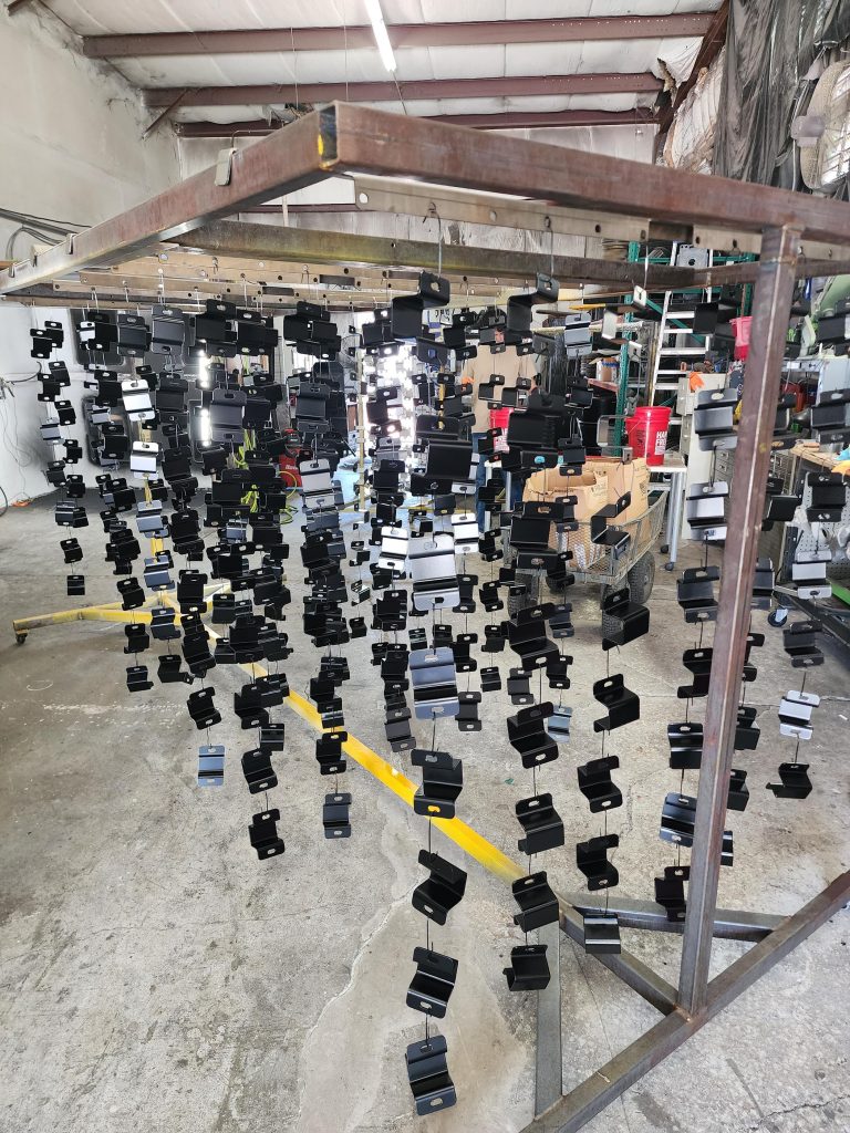 Rows of small brackets hanging from a workshop rack