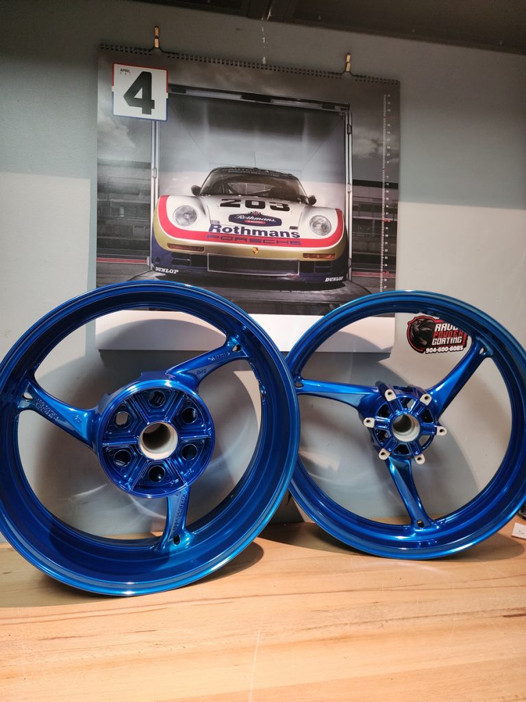 Pair of three-spoke motorcycle wheels on a workbench