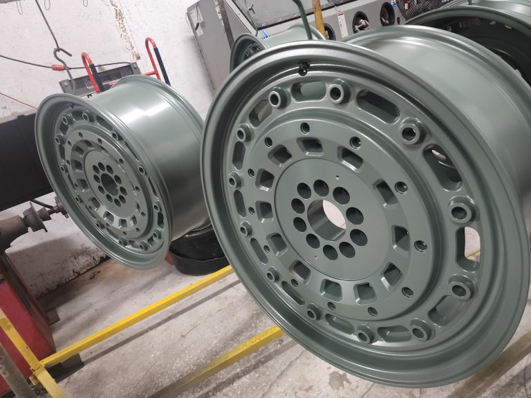 Pair of wheels with circular openings hanging from a rack