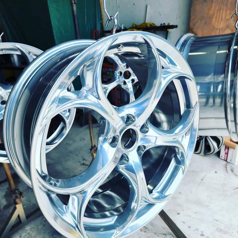 Pair of sculpted-spoke wheels on a workshop rack