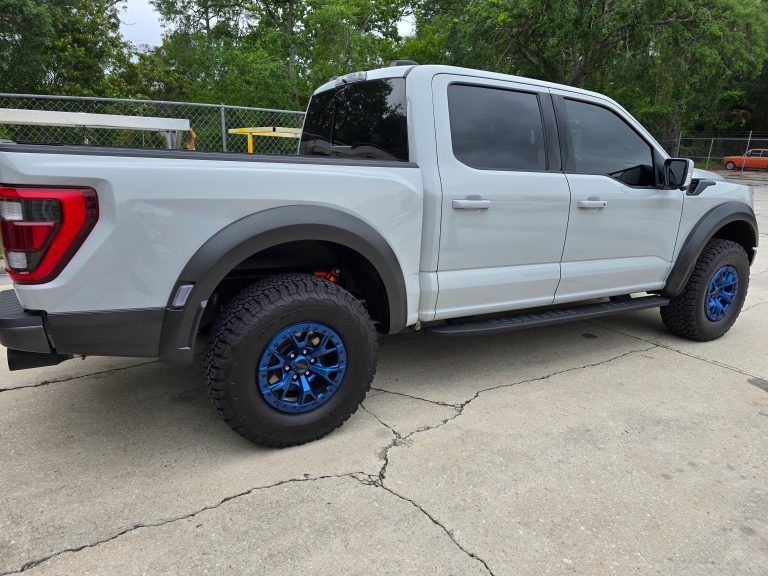 Pickup truck with custom wheels parked outside